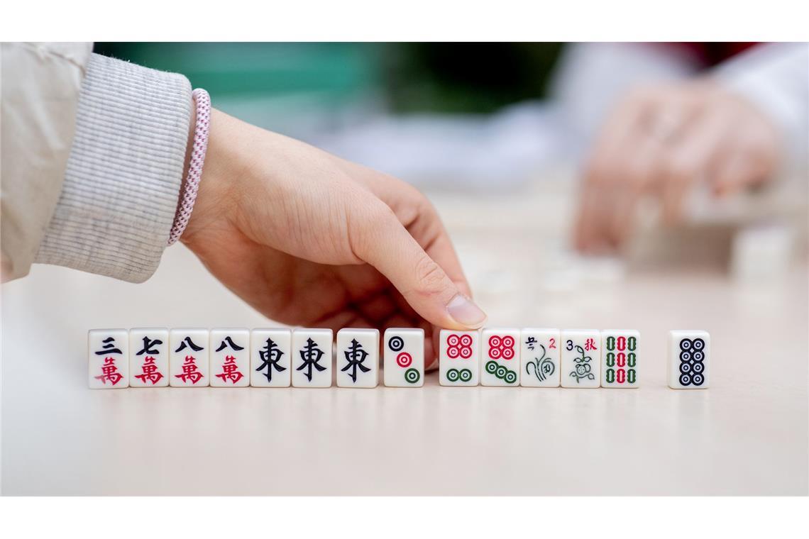 Besucher spielen bei dem chinesisches Neujahrsfest in den Gewächshäusern der Botanika in Bremen das chinesische Gesellschaftsspiel Mah-Jongg.