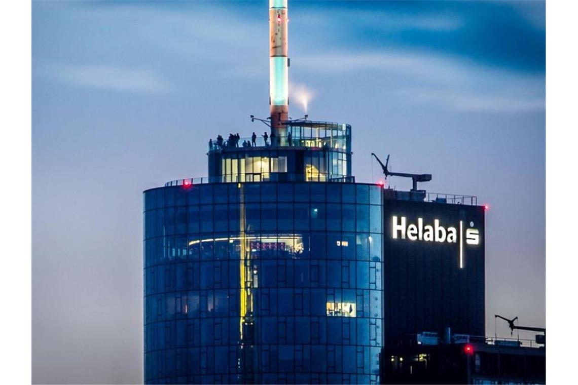 Besucher stehen abends in rund 198 Metern Höhe auf der Aussichtsterrasse des Main Towers, der auch die Landesbank Hessen-Thüringen (Helaba) beherbergt. Foto: Frank Rumpenhorst/dpa