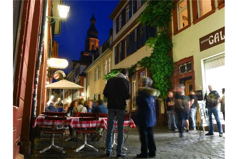 Besucher stehen in der Altstadt Heidelbergs. Foto: Uwe Anspach/Archivbild