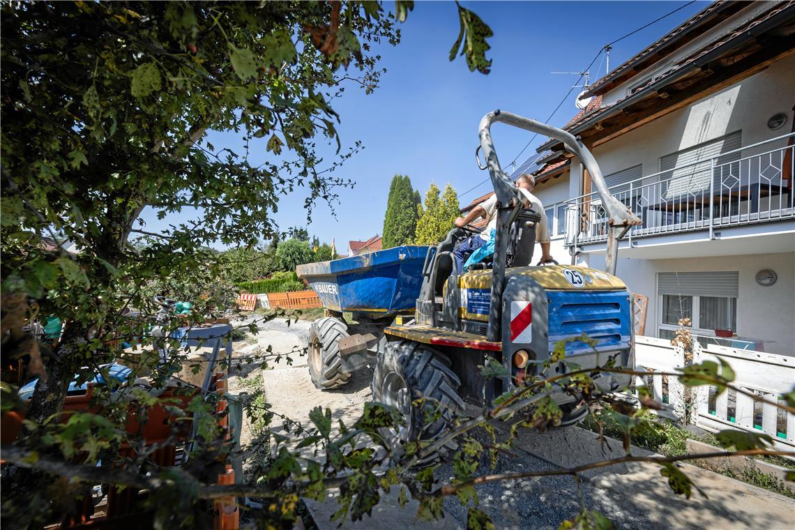 Komplizierteste Baustelle der Stadt ist in Sachsenweiler Beton und anderes Material wird im Muldenkipper quer durch die Gärten transportiert.