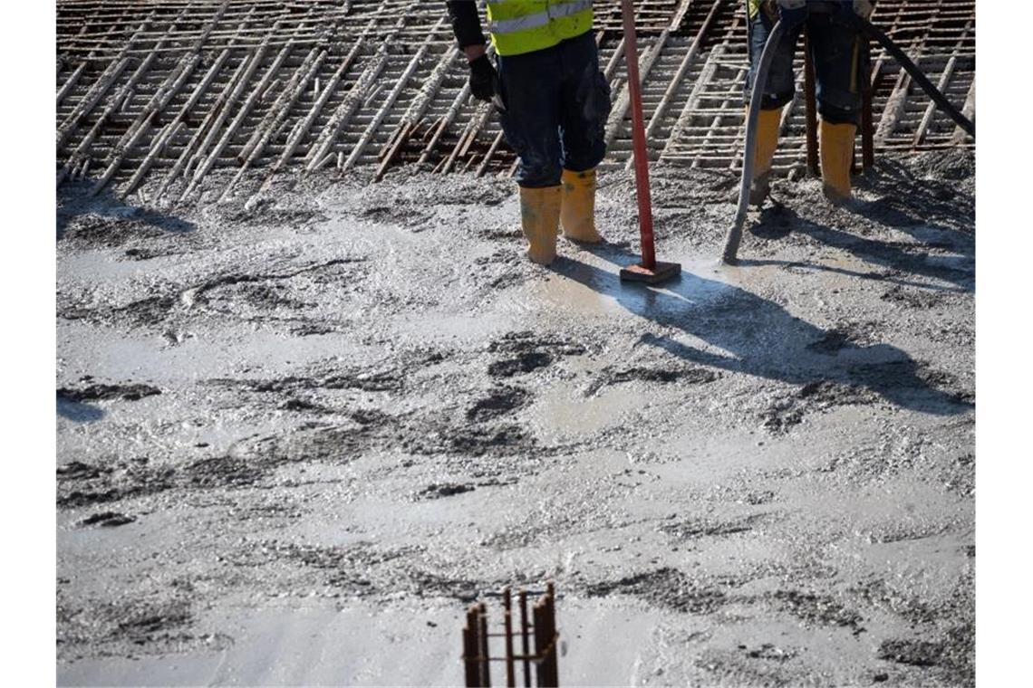 Betonbauer verarbeiten frischen Beton auf einer Baustelle in der Hafencity. Foto: Christian Charisius/dpa