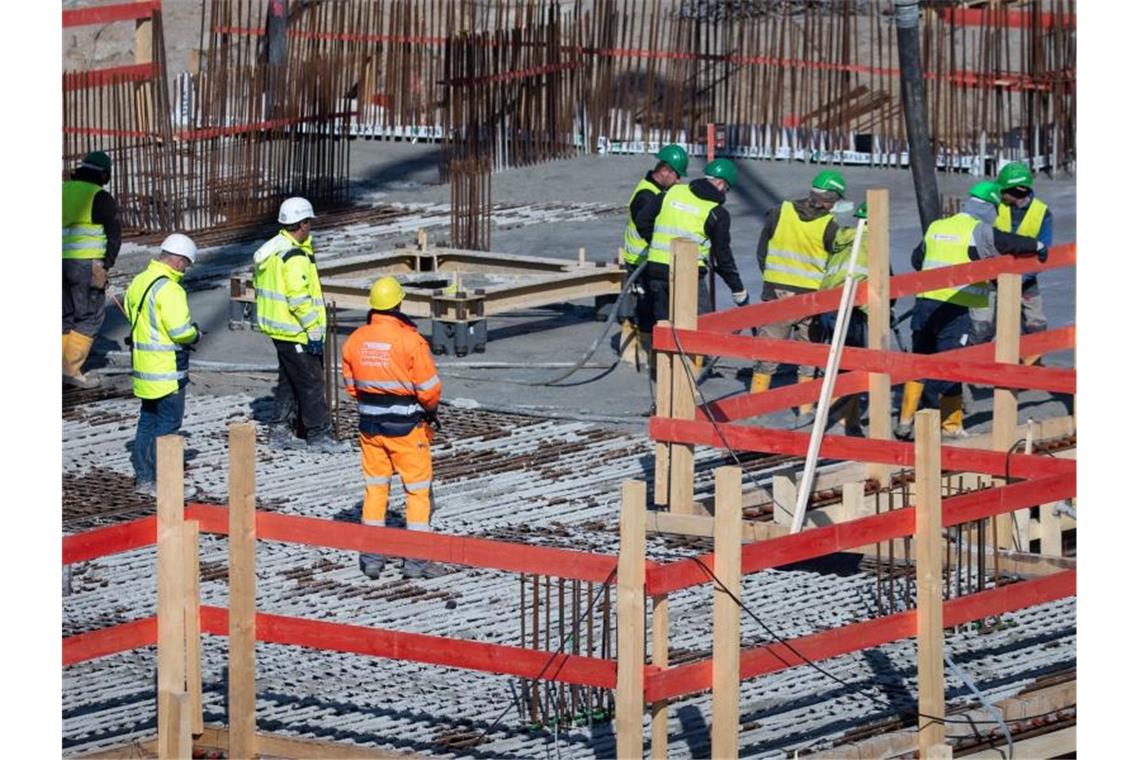 Betonbauer verarbeiten frischen Beton auf einer Baustelle in der Hamburger Hafencity. Foto: Christian Charisius/dpa