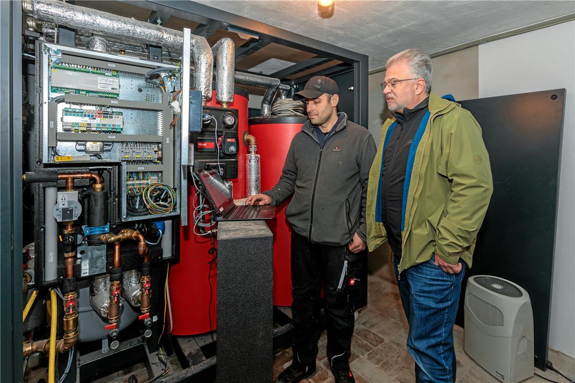 Betriebsleiter Abdyl Beha bei der Inbetriebnahme mit Hausherr Thomas Rieger. Im Keller steht das Herz der Anlage: die Steuerung sowie eine Warmwasserspeicher und ein Pufferspeicher, kompakt zusammengefasst vormontiert in einer Art Container (Smart Cube).