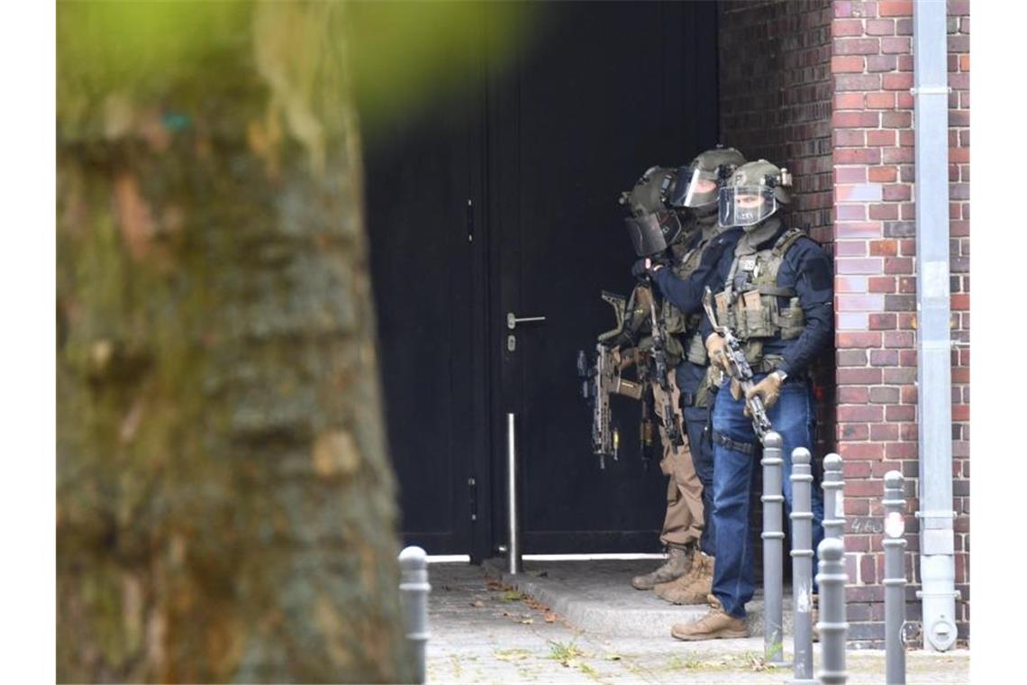 Bewaffnete Einsatzkräfte der Polizei vor dem Schulgebäude. Foto: Paul Zinken/dpa-Zentralbild/dpa