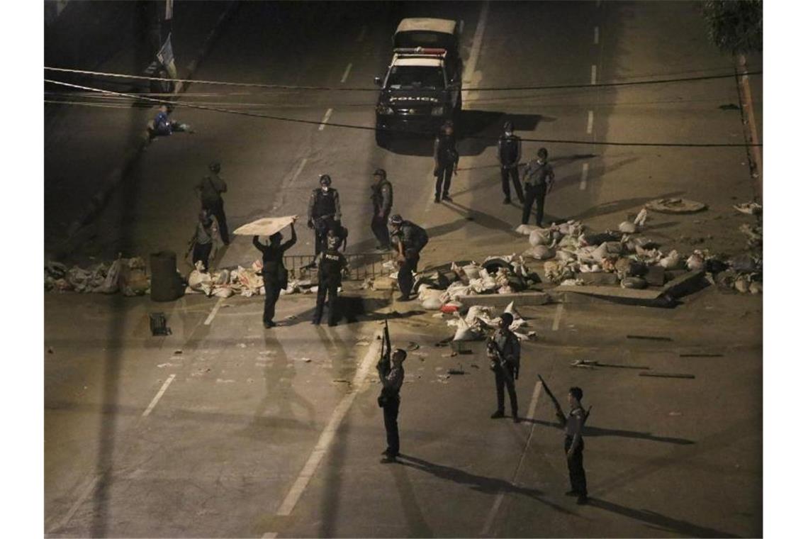 Bewaffnete Polizisten entfernen eine Straßenblockade, die von Demonstranten errichtet wurde. In vielen Städten gibt es weiterhin Proteste gegen die Militär-Junta im Land. Foto: Uncredited/AP/dpa