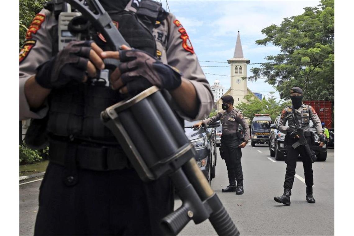 Bewaffnete Polizisten sichern die Umgebung ab. Foto: Yusuf Wahil/AP/dpa