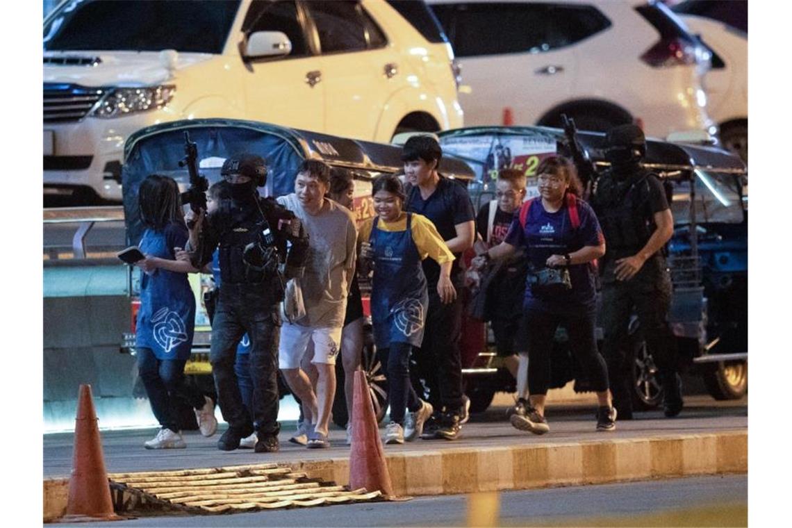 Amoklauf in Thailand: Soldat tötet 26 Menschen Bewaffnete Kommandosoldaten begleiten Menschen aus dem Einkaufszentrum. Foto: Sakchai Lalitkanjanakul/AP/dpa
