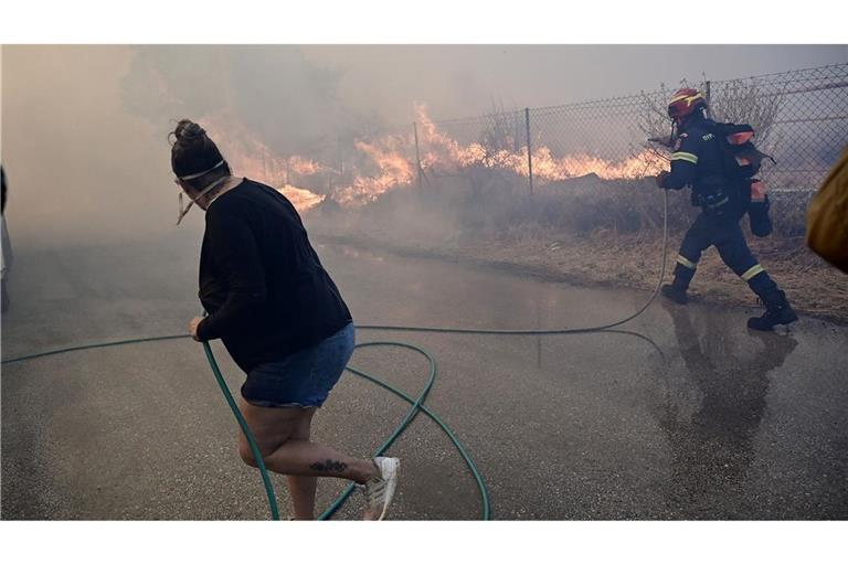 Bewohner und Feuerwehrleute bekämpfen die Flammen.