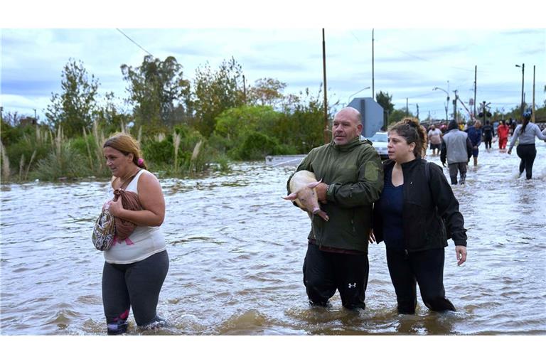 Bewohner waten durch überflutete Straßen nach heftigen Regenfällen in Campana, Argentinien.
