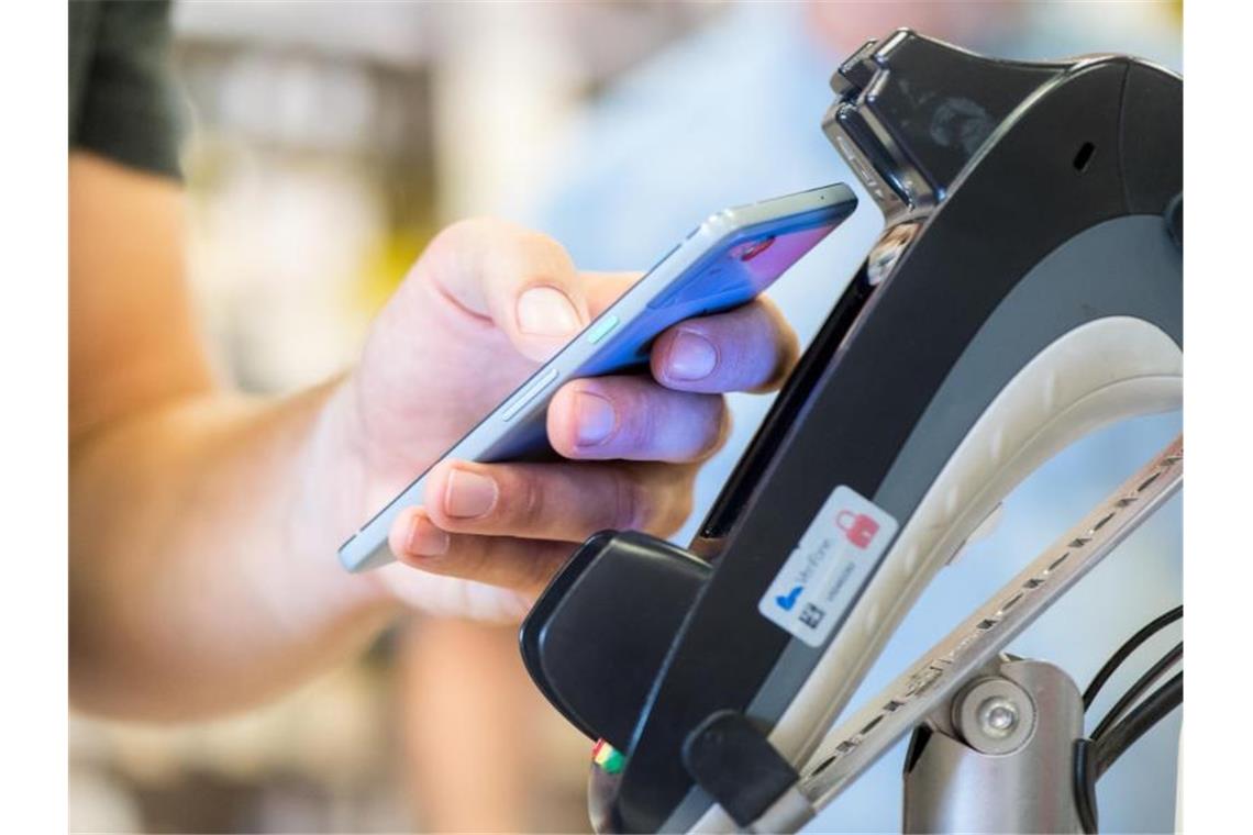 Bargeldloses Bezahlen per Girocard auf Rekordniveau Bezahlen mit dem Smartphone im Supermarkt. Foto: Franziska Gabbert/dpa