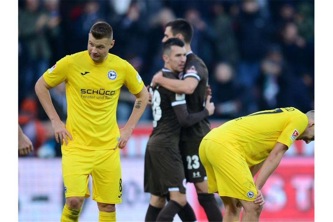 Zweitliga-Spitzentrio enttäuscht zum Jahresabschluss Bielefelds Florian Hartherz (l) und Cedric Brunner (r) reagieren enttäuscht nach der Partie gegen FC St. Pauli. Foto: Daniel Bockwoldt/dpa