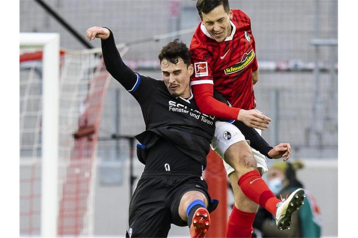 Freiburg im Pokal mit Flekken und Schlotterbeck Bielefelds Janni Serra (l) in Aktion gegen Freiburgs Keven Schlotterbeck (r). Foto: Tom Weller/dpa