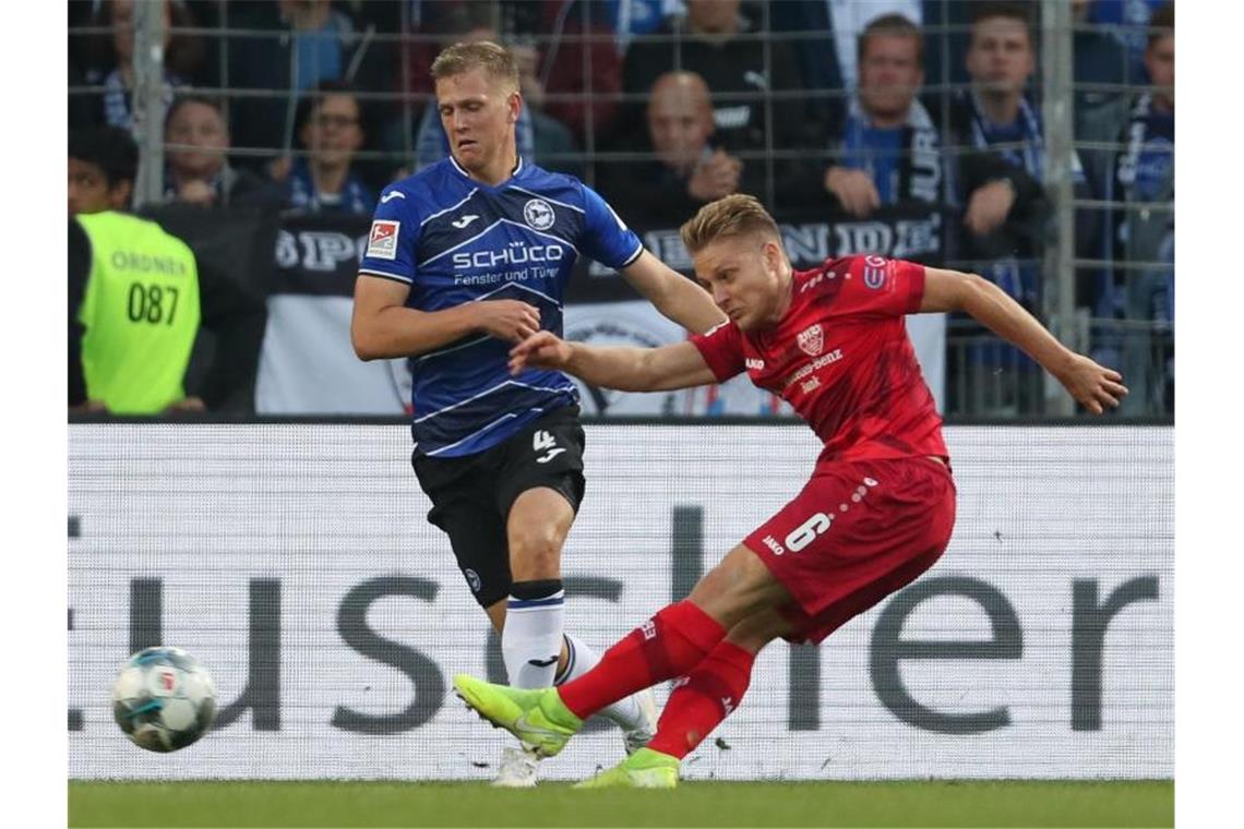 Zweitliga-Spitzenreiter Stuttgart setzt sich ab Bielefelds Joakim Nilsson (l) im Kampf um den Ball mit Santiago Ascacibar (r) vom VfB Stuttgart. Foto: Friso Gentsch