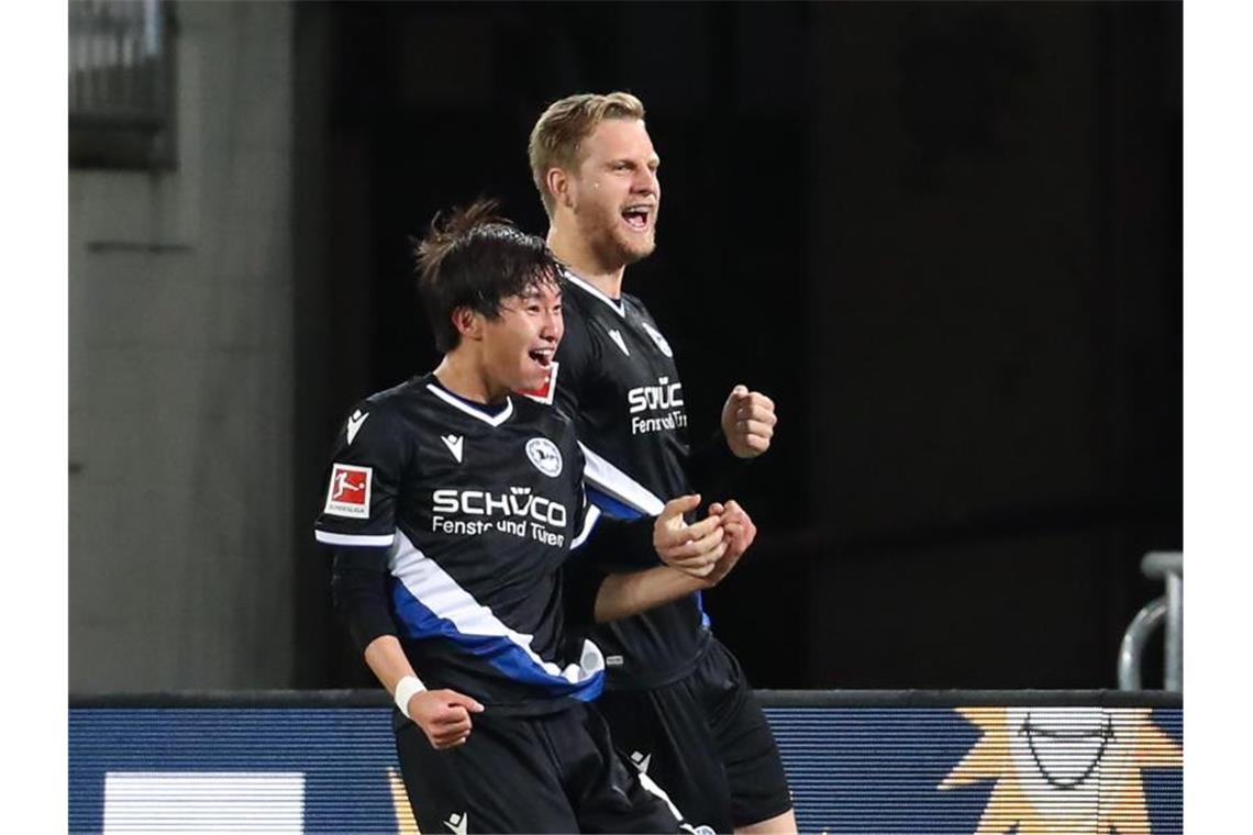 Bielefelds Masaya Okugawa (l) und Arne Maier feiern das Tor zum 1:0. Foto: Friso Gentsch/dpa