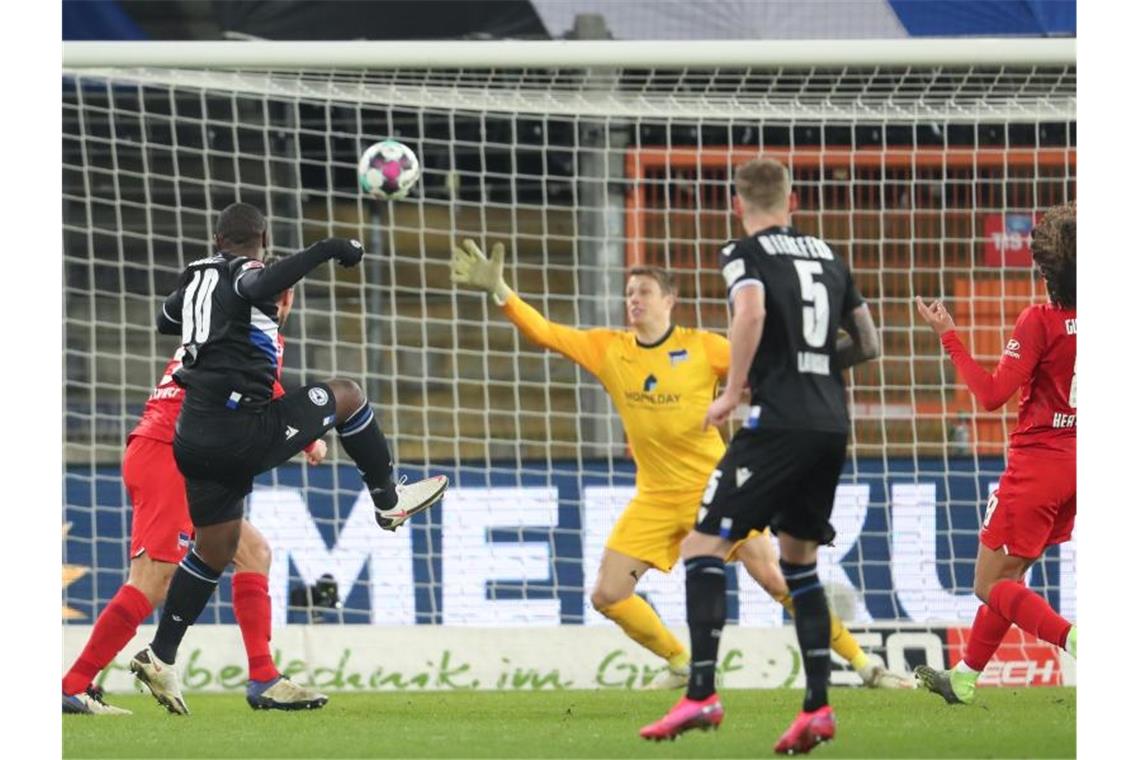 Bielefelds Reinhold Yabo (l) erzielt den Treffer zum 1:0 gegen Herthas Torwart Alexander Schwolow (M). Foto: Friso Gentsch/dpa