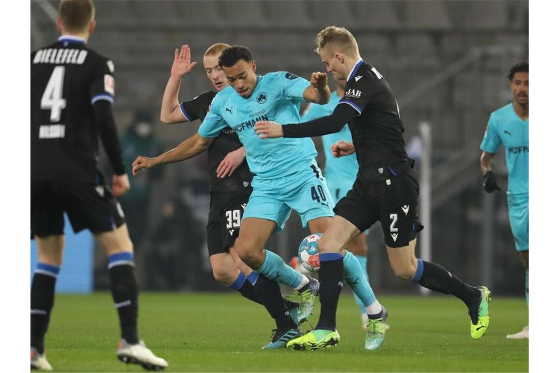 Kein Sieger im Duell zwischen Bielefeld und Greuther Fürth Bielefelds Sebastian Vasiliadis (2.v.l.) und Amos Pieper (2.v.r.) kämpfen um den Ball mit Fürths Jamie Leweling (M). Foto: Friso Gentsch/dpa