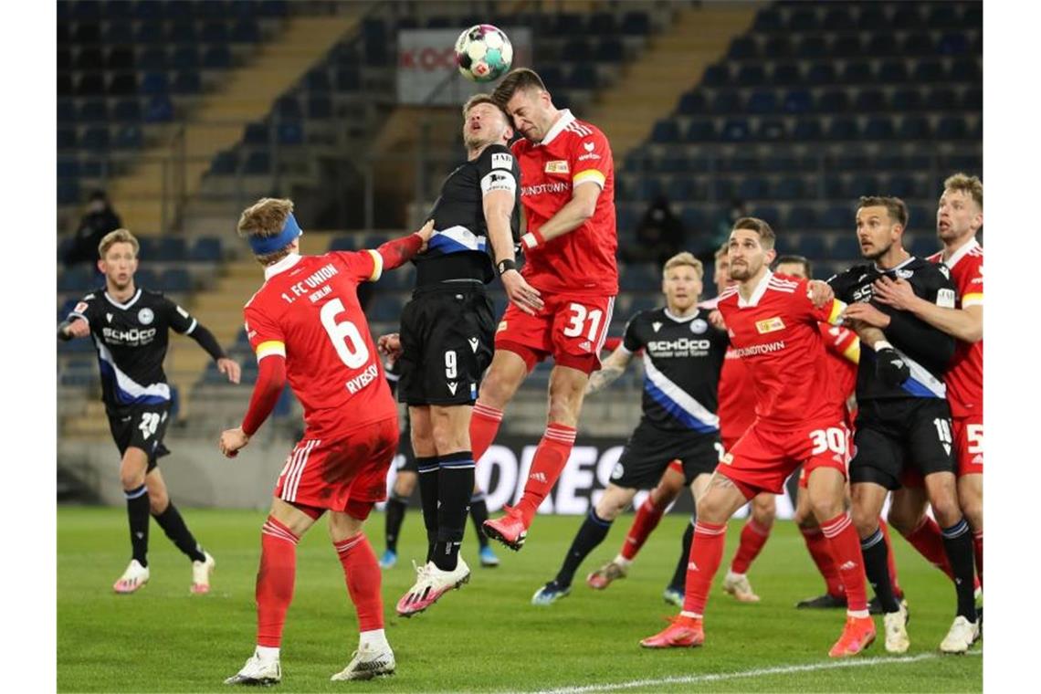 Bielefeld holt bei Kramer-Debüt einen Punkt gegen Union Bielefelds Stürmer Fabian Klos (M, l) und Unions Abwehrspieler Robin Knoche (M, r) liefern sich ein Kopfballduell im Strafraum der Berliner. Foto: Friso Gentsch/dpa
