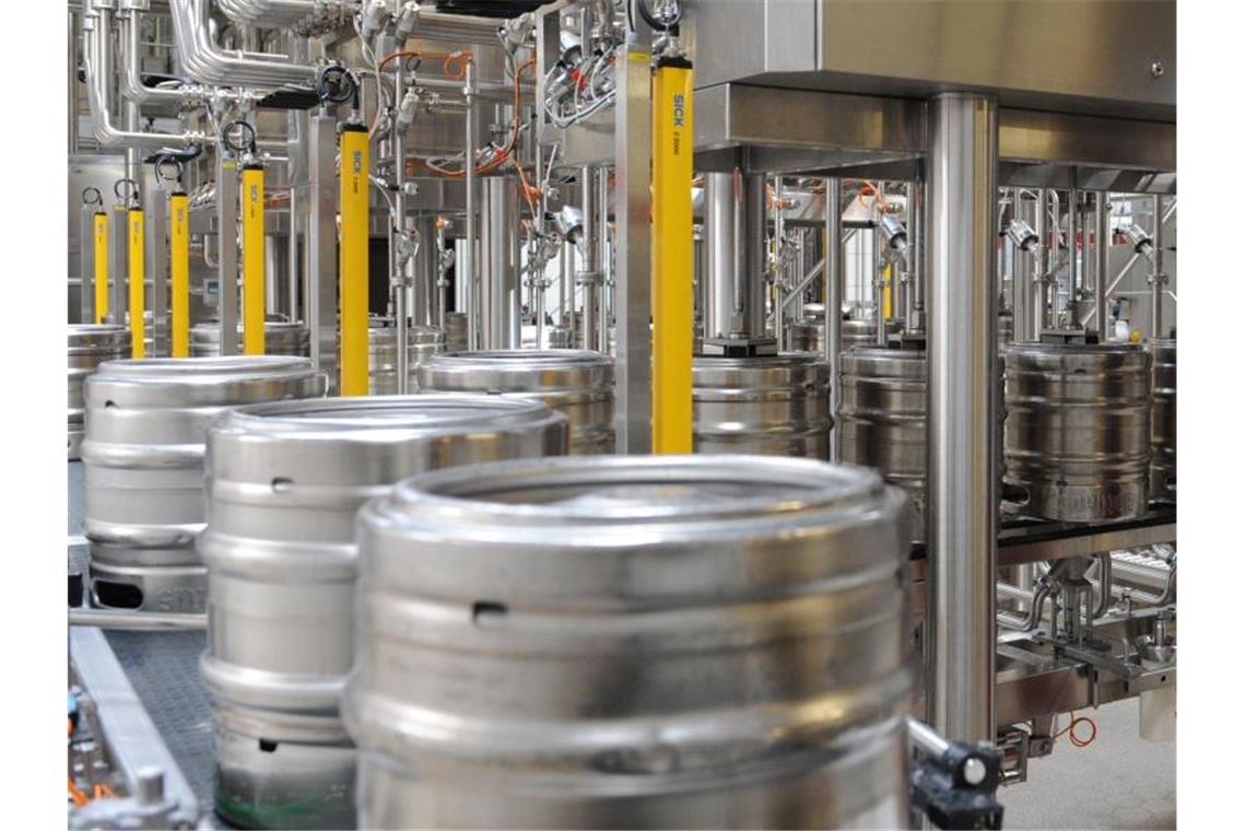 Bier wird in einer Brauerei in einer Abfüllanlage in Bierfässer gefüllt. Foto: Patrick Seeger/dpa/Symbolbild