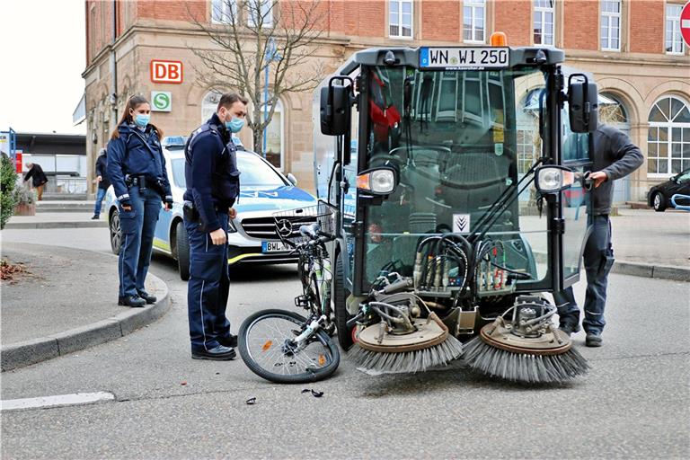 Fahrradfahrerin unter Kehrmaschine eingeklemmt