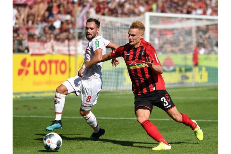 Birger Verstraete von Köln und Philipp Lienhart von Freiburg (l-r.) im Zweikampf um den Ball. Foto: Patrick Seeger