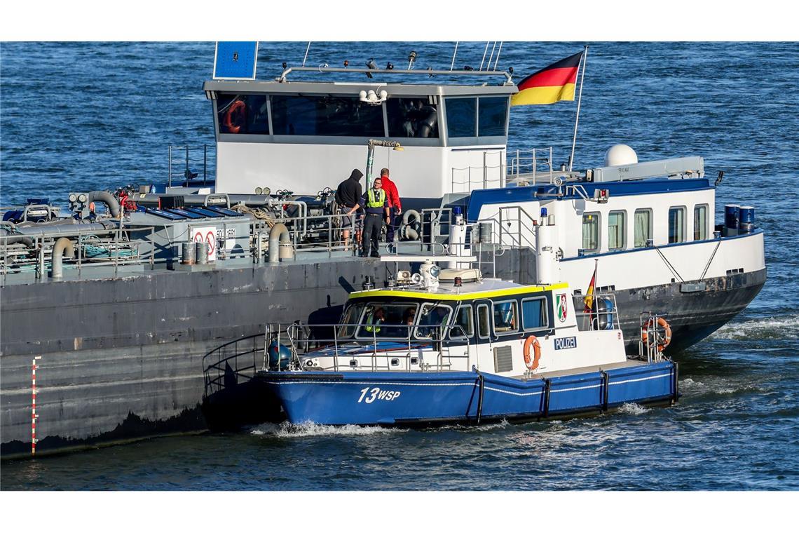 Bitte mal Führerschein und Fahrzeugschein zeigen. Ein Polizeiboot der Wasserschutzpolizei Duisburg liegt bei der Kontrolle von Binnenschiffen seitlich an einem Tankschiff auf dem Rhein.