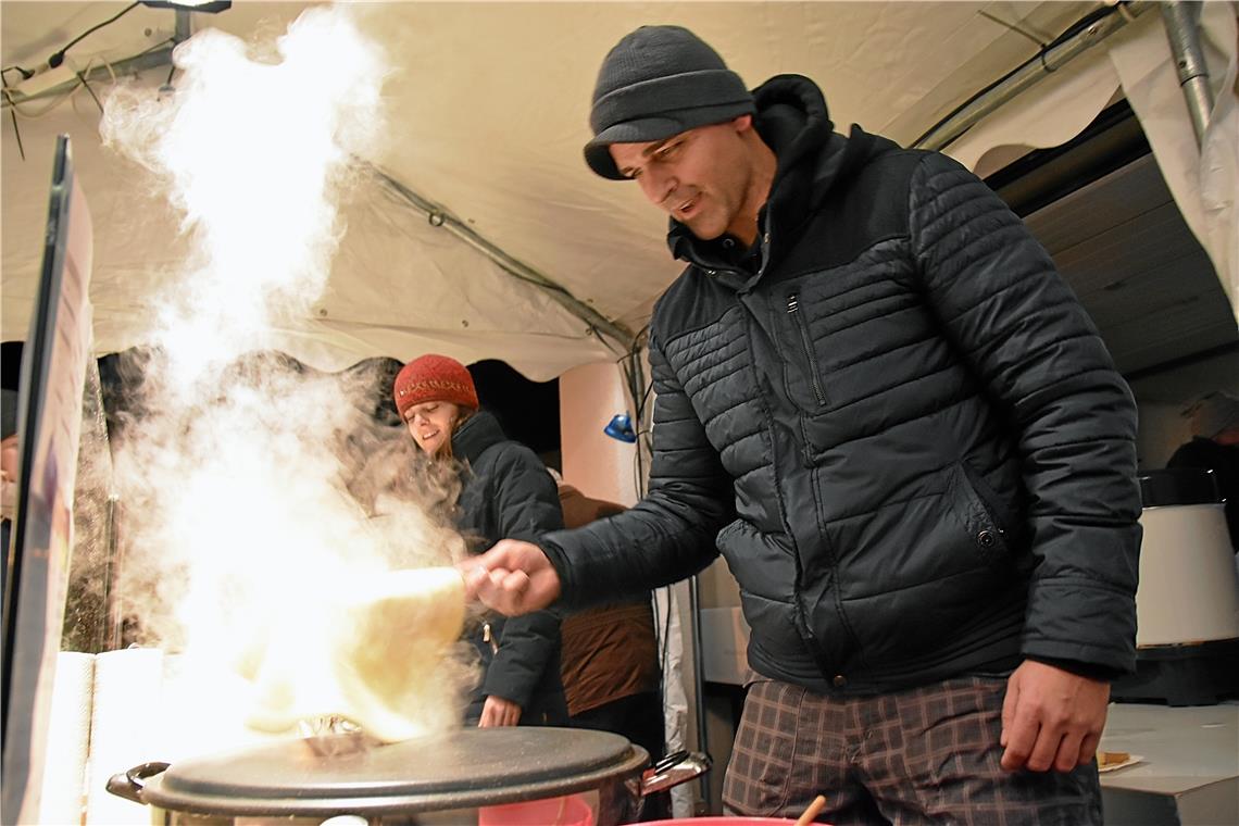 Bitte wenden. Pastor Sascha Kielwein backt Crêpes am Stand der "Gemeinde Gottes"...