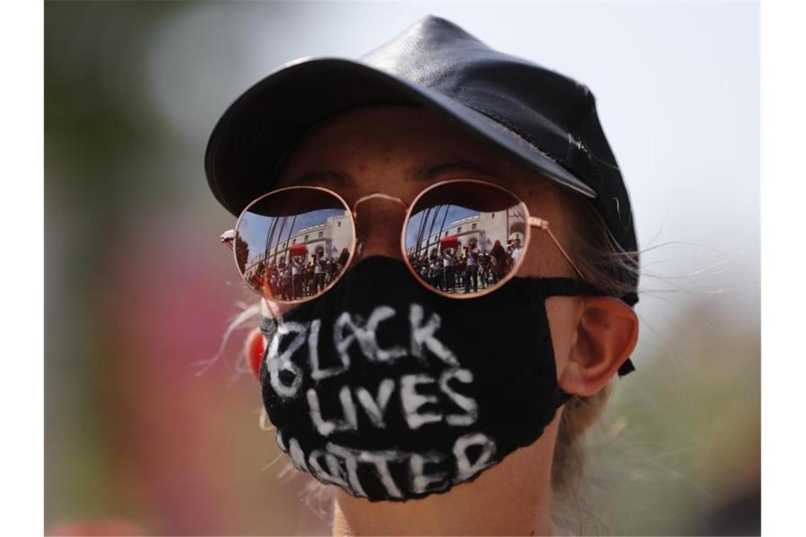 Bürgerrechtler verklagen Trump - „Marsch auf Washington“ „Black Lives Matter“: In der Sonnebrille einer Demonstrantin in Los Angeles spiegelt sich eine Kundgebung für den getöteten George Floyd. Foto: Jae C. Hong/AP/dpa