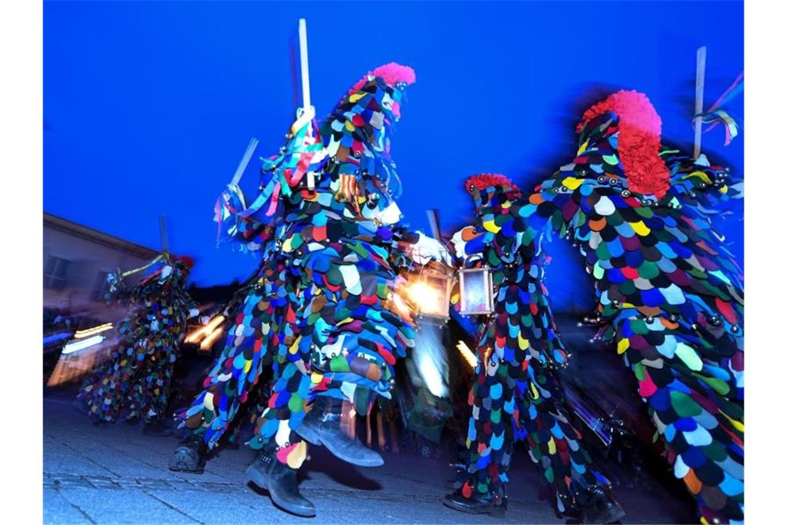 Blätzlebuebe der Konstanzer Narren tanzen am sogenannten schmutzigen Dunschtig mit ihren Laternen. Foto: Felix Kästle/dpa