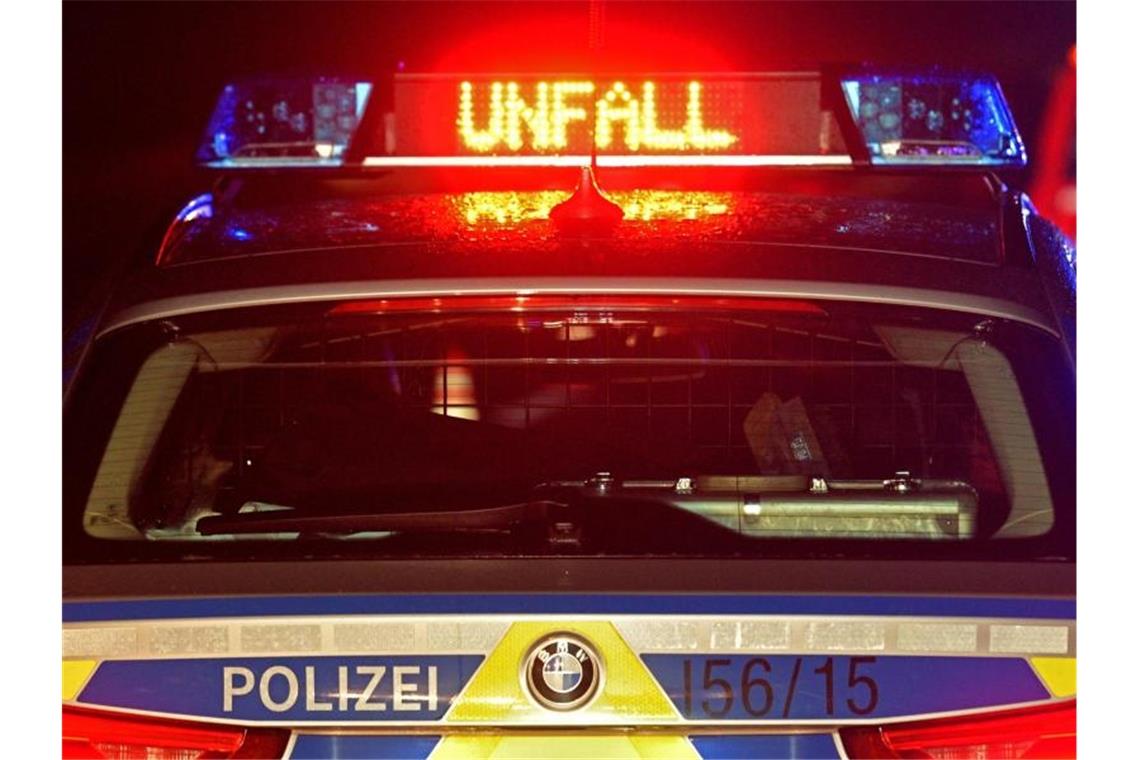 Blaulicht und der LED- Schriftzug "Unfall" auf dem nassen Dach eines Polizestreifenwagens. Foto: Stefan Puchner/dpa/Archiv