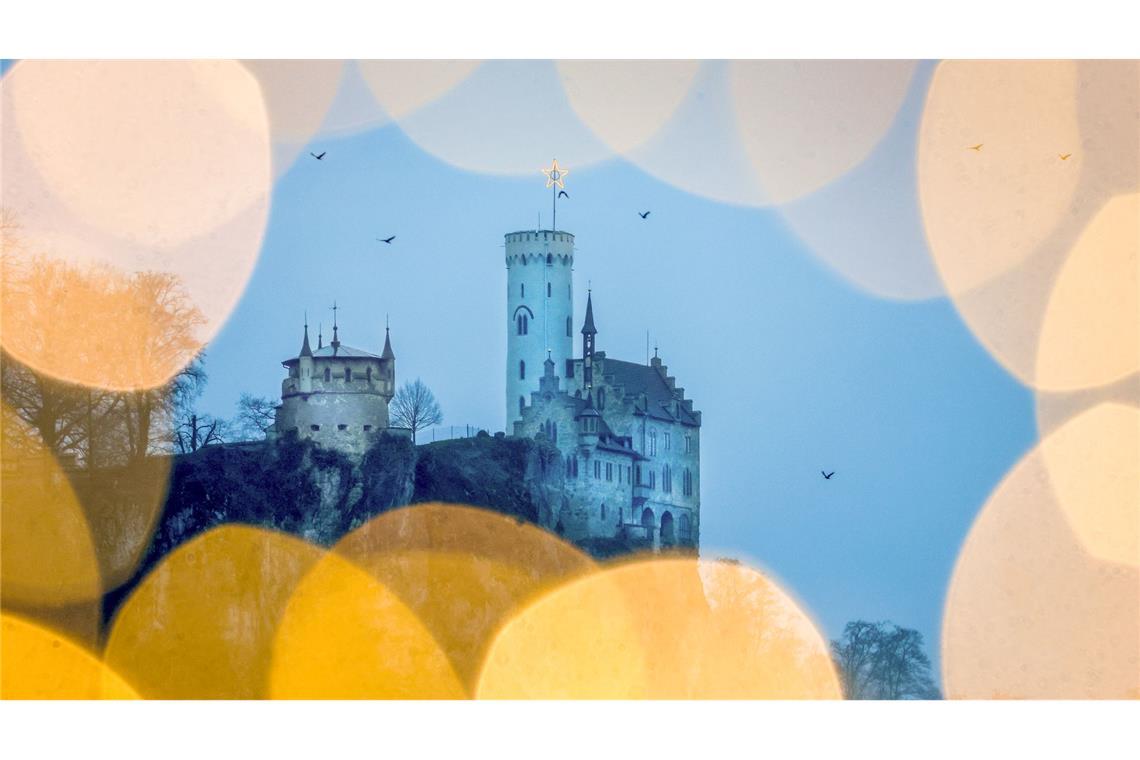 Bilder des Tages Blick am Morgen bei regnerischem Wetter durch eine Lichterkette auf das Schloss Lichtenstein auf der Schwäbischen Alb.