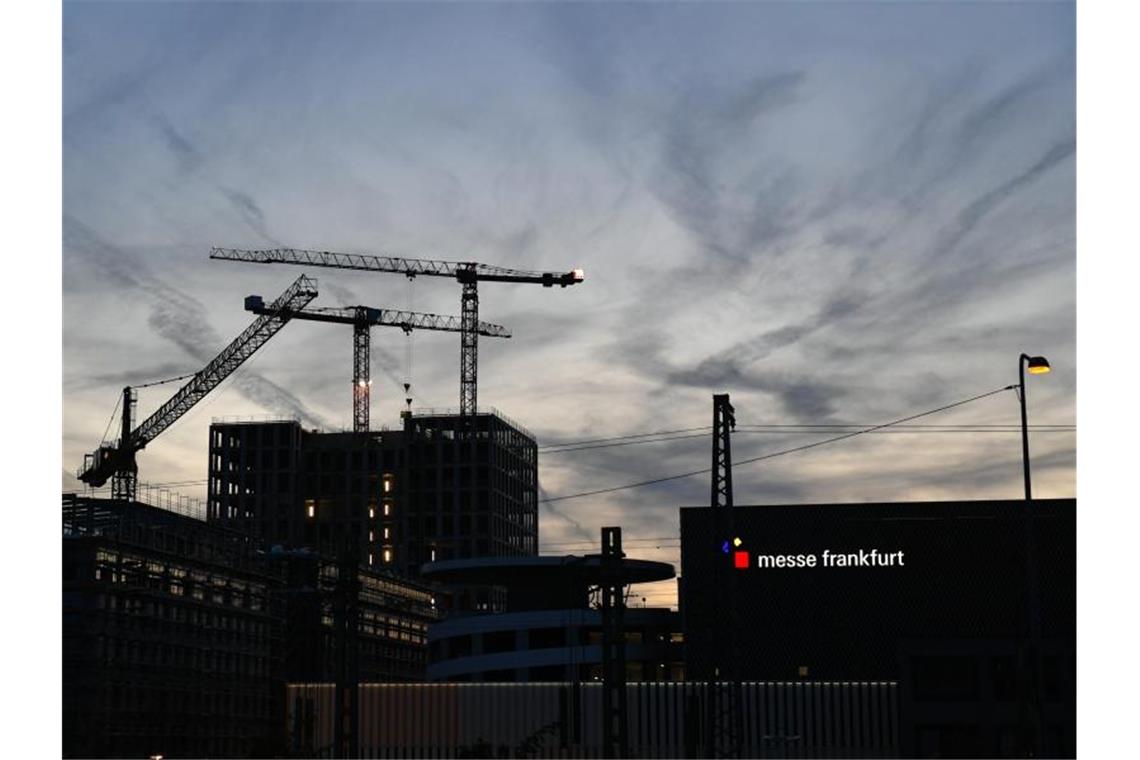 Blick auf Baukräne am Gelände der Frankfurter Messe am Abend. Foto: Jens Kalaene/dpa/Archivbild