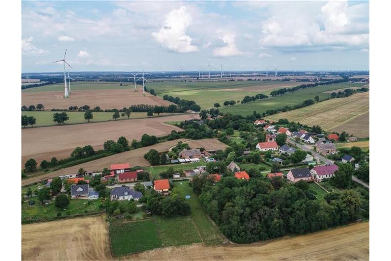 Blick auf das Dorf Carzig mit vielen Windenergieanlagen im Hintergrund. Die geplante Regelung für den Abstand von Windrädern und Wohnsiedlungen sorgt für Ärger. Foto: Patrick Pleul/zb/dpa