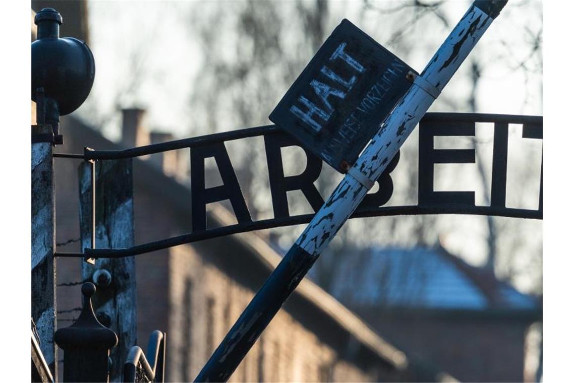 Blick auf das Eingangstor des ehemaligen deutschen Konzentrationslagers Auschwitz mit dem zynischen Schriftzug „Arbeit macht frei“. Foto: Robert Michael/zb/dpa