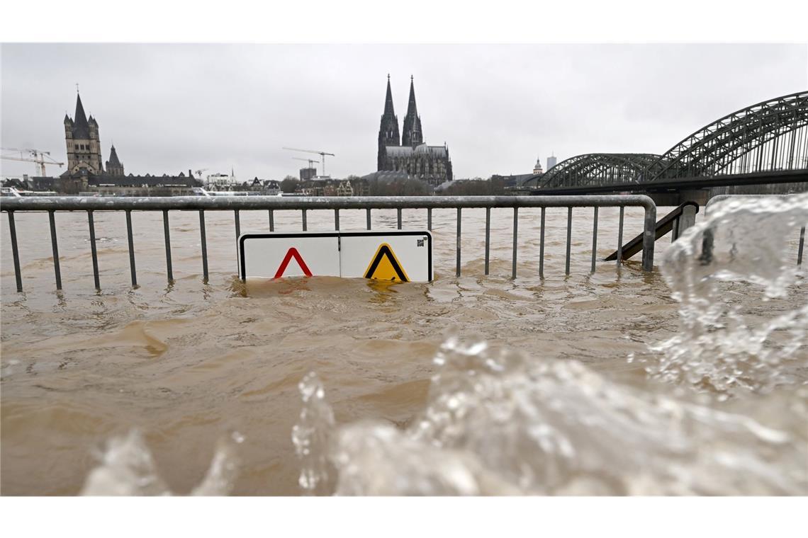 Blick auf den Hochwasser führenden Rhein vor dem Dom und der Hohenzollernbrücke.