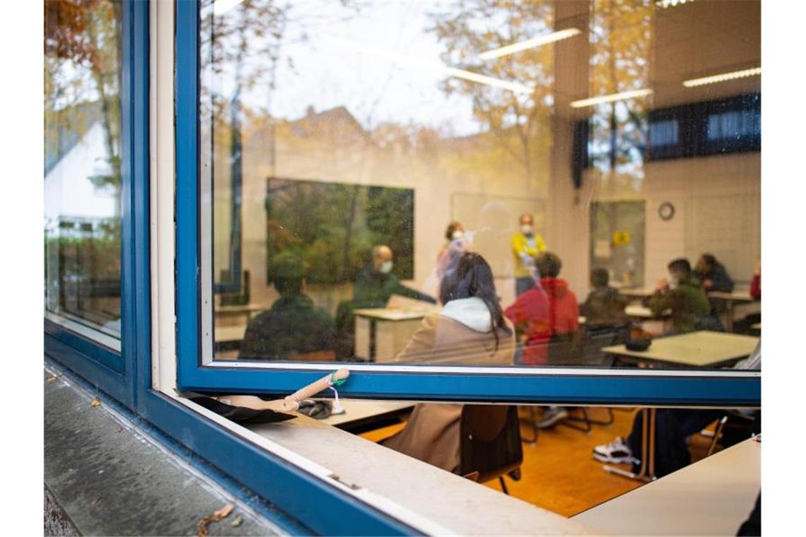 Blick durch das offen stehende Fenster in den Klassenraum einer Schule in Gütersloh. Foto: Guido Kirchner/dpa