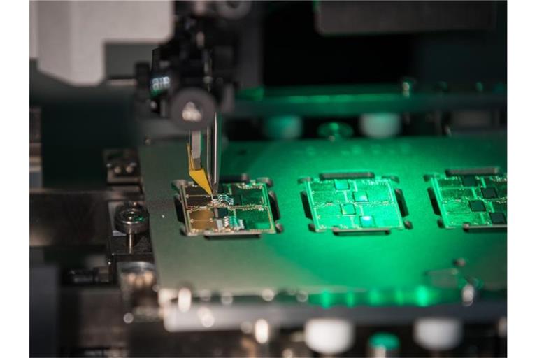 Blick in einen Verbindungsprozess (Aluminiumbonden) zwischen Elektronikträger und Halbleiter, aufgenommen in der Produktion von 48-Volt-Elektromotoren bei Continental. Foto: Daniel Karmann/dpa