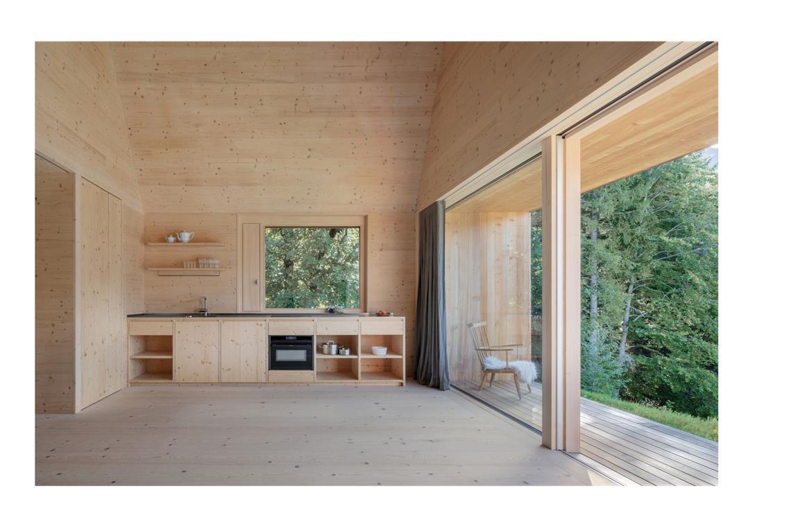 Die besten einfachen Häuser Europas – auch von Stuttgarter Architekten Blick ins Innere des Holzbaus in Laterns. Bodentiefe und breite Fensterfronten sorgen für viel Licht. Die Küchenzeile besteht aus Fichte-Dreischichtplatten. Geheizt wird mit Wärmepumpe mit Erdsonde.