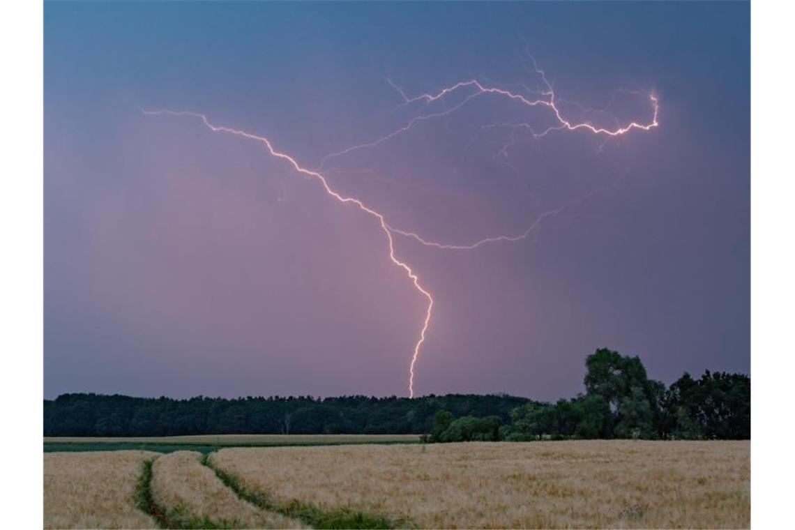 Blitze eines Gewitters erhellen den Abendhimmel. Foto: Patrick Pleul/dpa-Zentralbild/Archiv