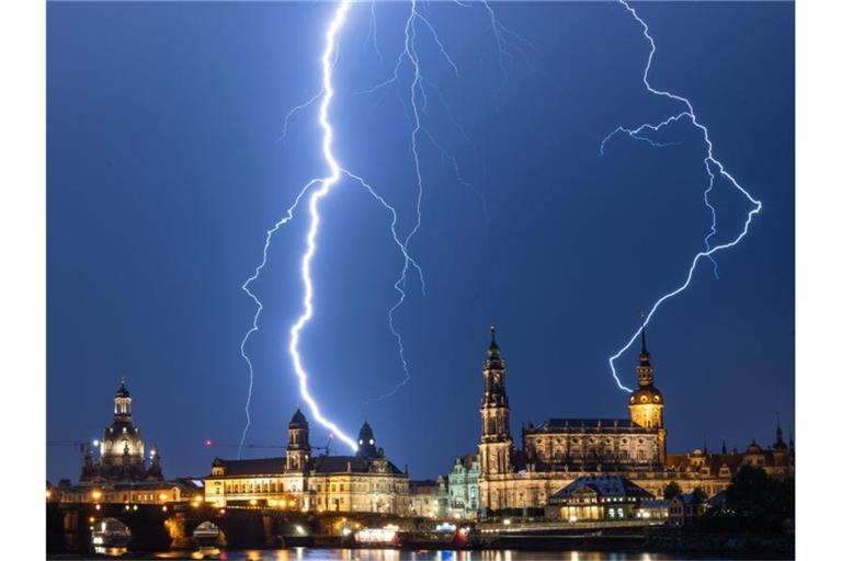Blitze schlagen während eines Gewitters am Abend in die historische Altstadtkulisse von Dresden mit der Frauenkirche (l-r), dem Ständehaus, der Hofkirche und dem Hausmannsturm ein. Foto: Robert Michael
