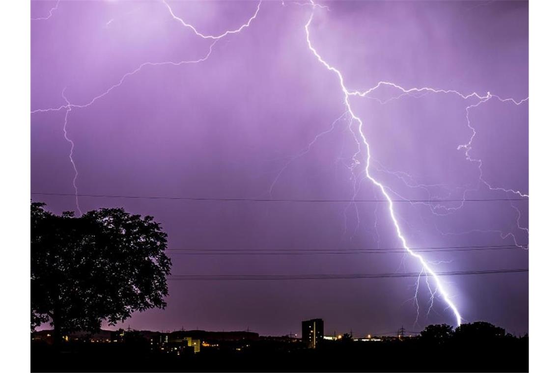 Blitze zucken während eines Gewitters am abendlichen Himmel in Stuttgart. Foto: Christoph Schmidt/Archivbild