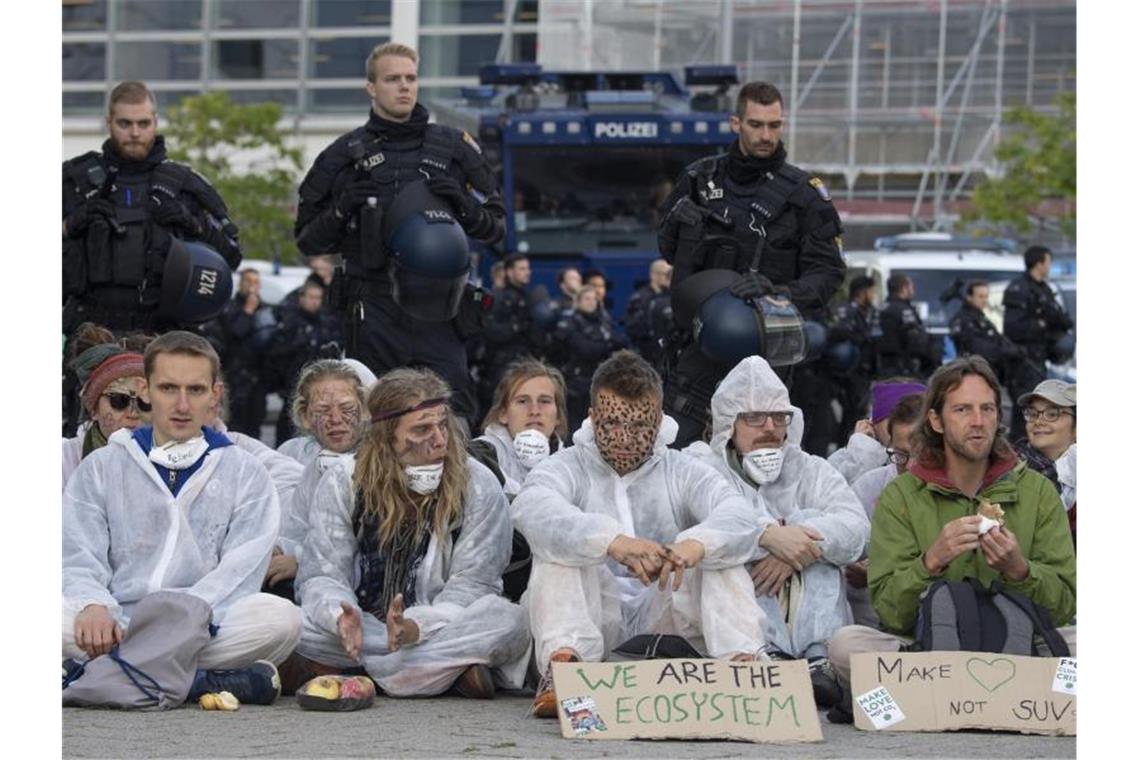 Klima-Aktivisten blockieren Haupteingang der IAA Blockadeaktion wird von Polizisten aufmerksam verfolgt. Foto: Boris Roessler