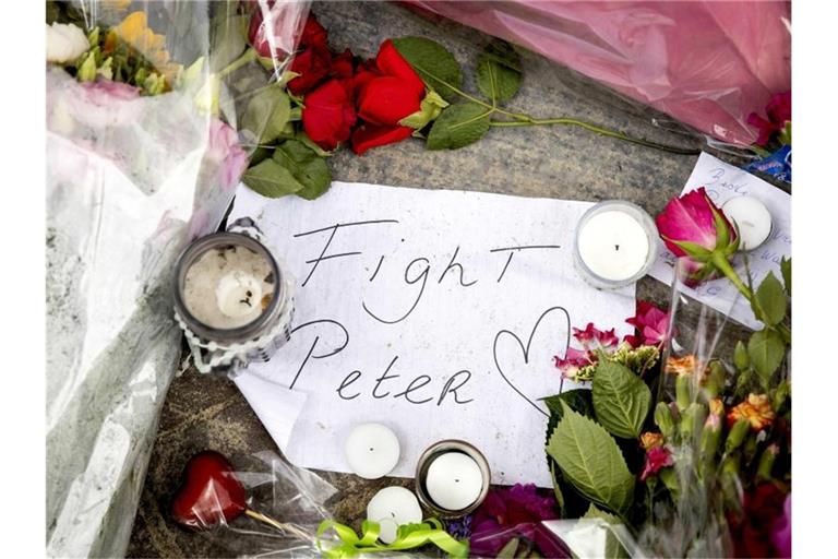Blumen, Kerzen und eine Botschaft mit "Fight Peter" liegen am Tatort. Foto: Koen Van Weel/ANP/dpa