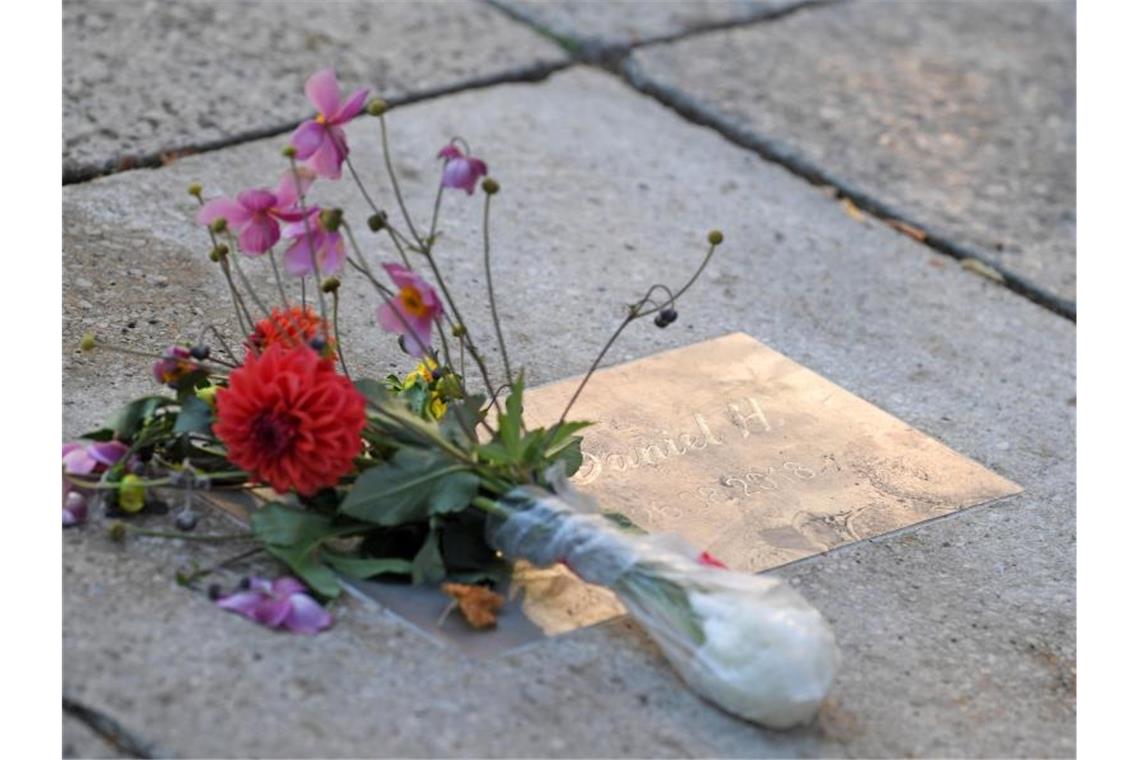 Blumen liegen an einer Gedenkplatte für den getöteten Daniel H. in Chemnitz. Foto: Hendrik Schmidt