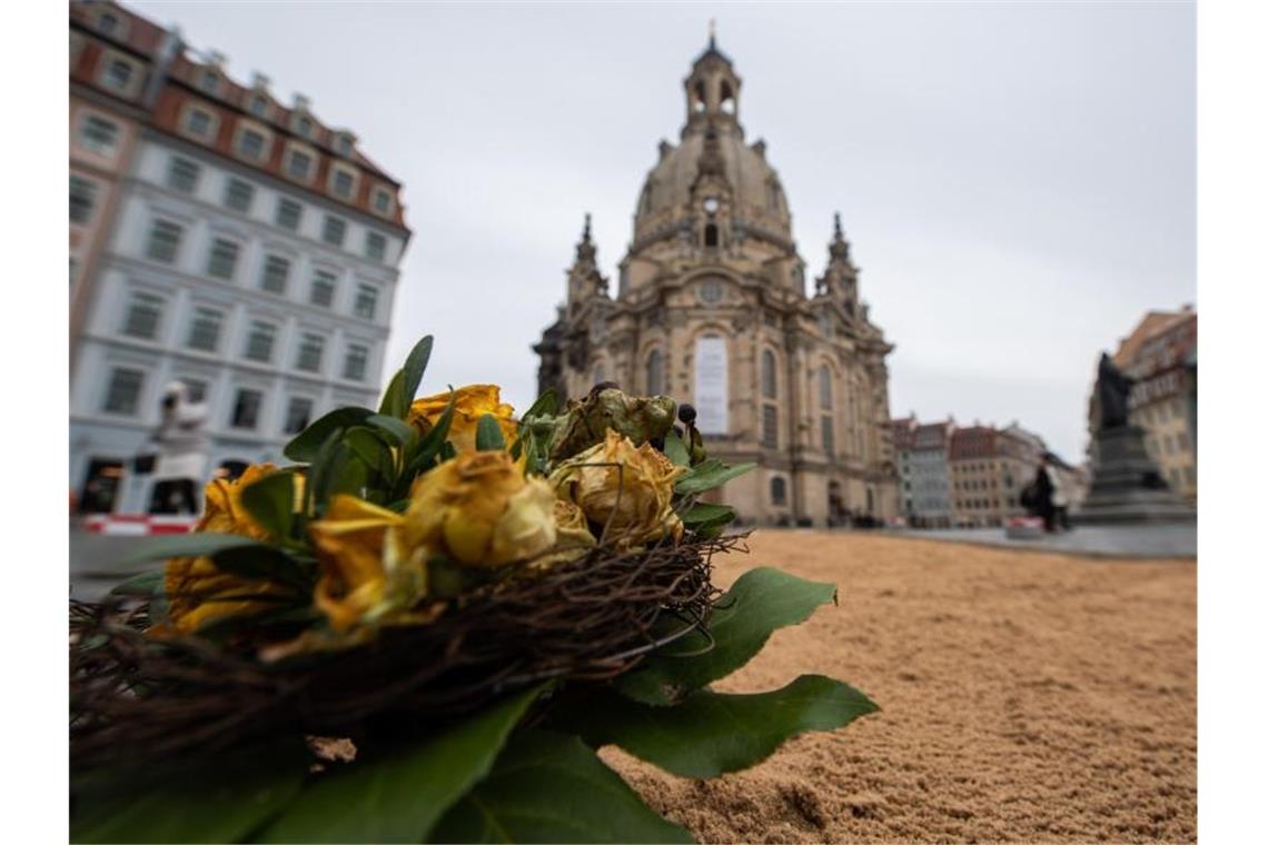 Blumen liegen auf dem Neumarkt vor der Frauenkirche. Foto: Robert Michael/dpa-Zentralbild/dpa