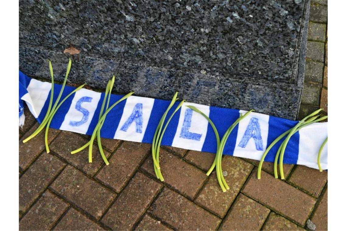 Keine Hoffnung mehr für verschollenen Fußballprofi Sala Blumen liegen auf einem Fanschal mit dem Namen Sala vor dem Cardiff City Stadion. Foto: Ben Birchall
