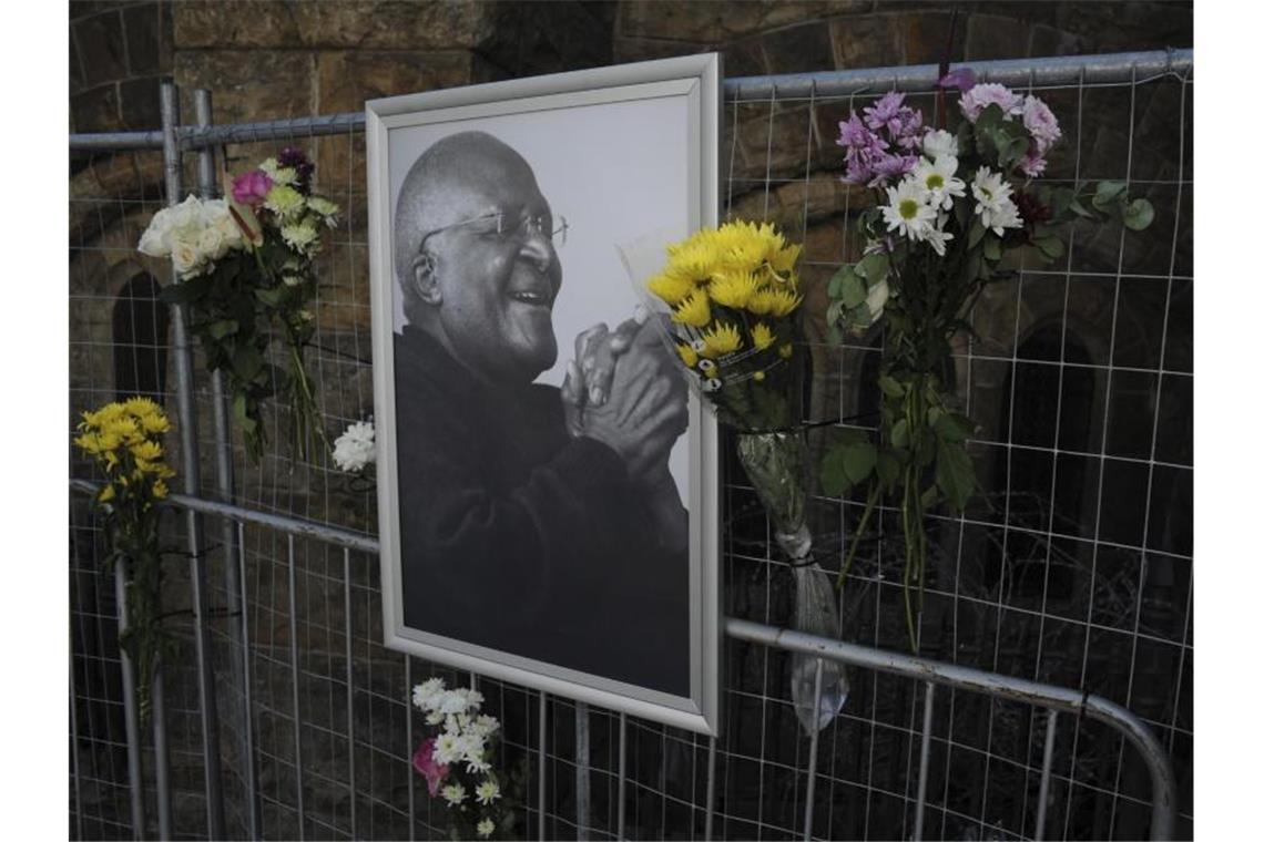 Blumen und ein Foto von Desmond Tutu an einem Gerüst in der St. George's Kathedrale in Kapstadt. Foto: AP/dpa