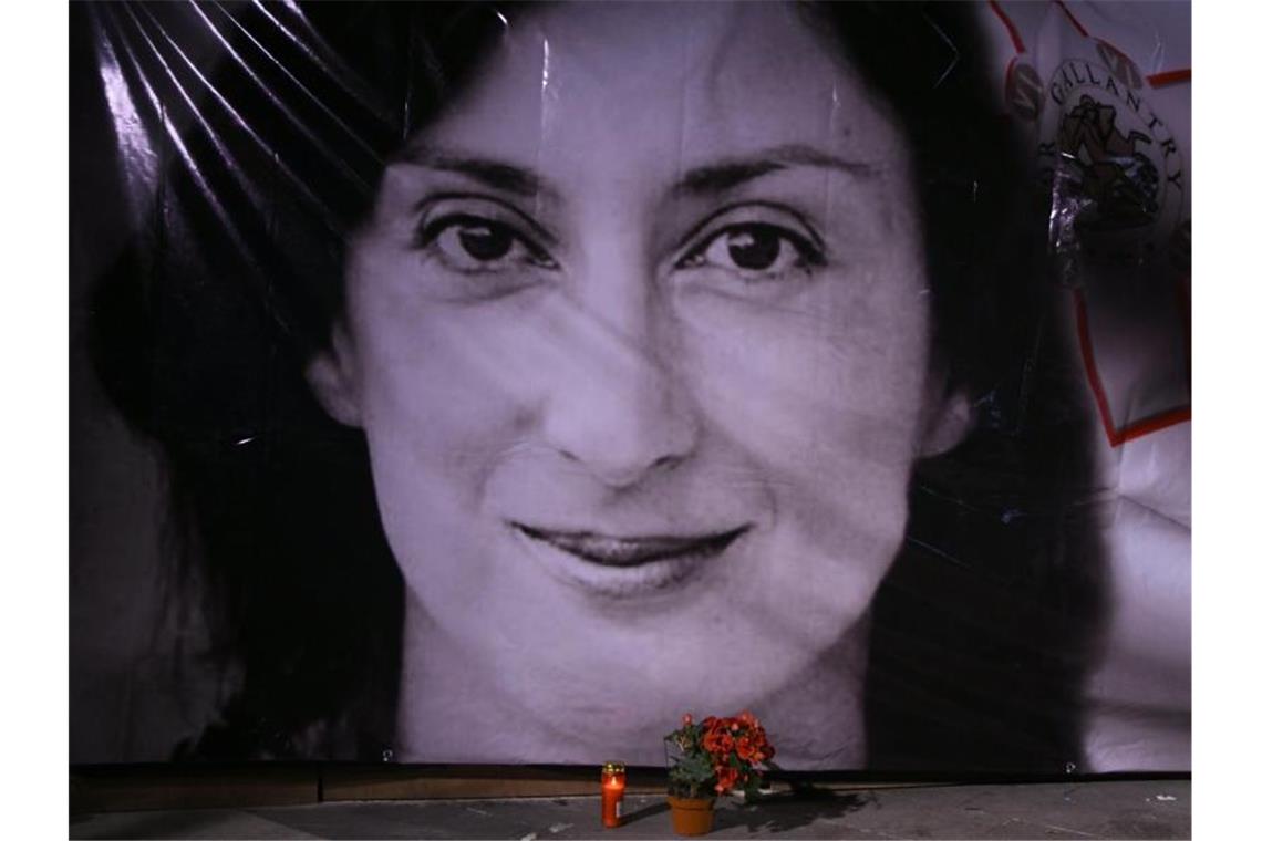 Urteil nach Mord an Journalistin in Malta: 15 Jahre Haft Blumen und eine Kerze liegen vor einem Porträt der ermordeten Enthüllungsjournalistin Daphne Caruana Galizia in Valletta. Foto: Jonathan Borg/AP/dpa