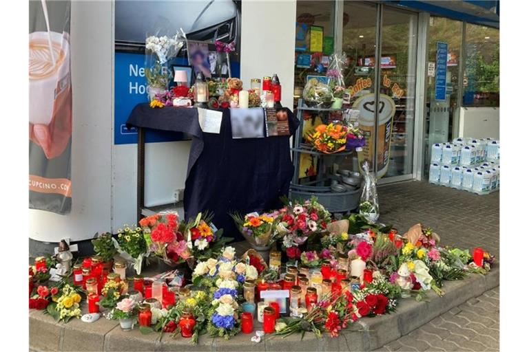 Blumen und Kerzen erinnern an einer Tankstelle in Idar-Oberstein an den jungen Kassierer, der am 18. September 2021 von einem mit einer Pistole bewaffneten Mann erschossen wurde. Foto: Birgit Reichert/dpa