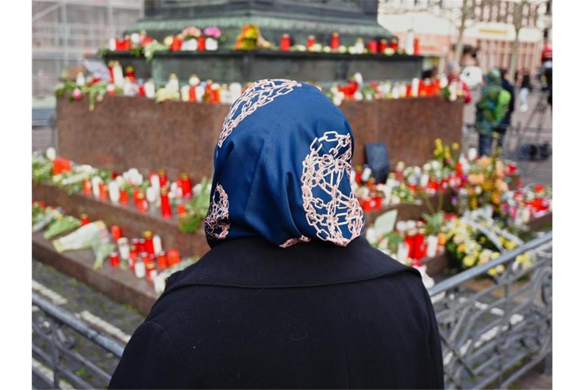 Blumen und Kerzen liegen am Brüder-Grimm-Nationaldenkmal in Hanau. Foto: Nicolas Armer/dpa