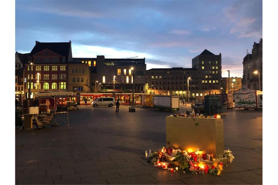 Blumen und Kerzen liegen auf dem Marktplatz in Halle. Foto: Marek Majewsky/dpa
